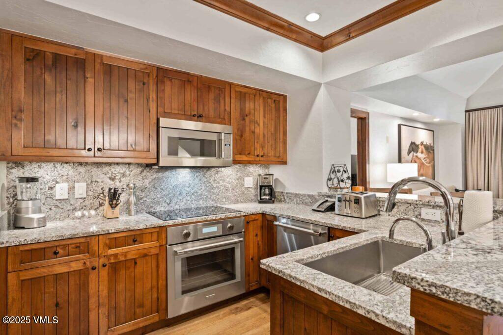 100 Bachelor Ridge Road, Unit 3508/09 Avon, CO 81620 - Photo 5 of 33 a kitchen with granite countertop a sink a stove and cabinets