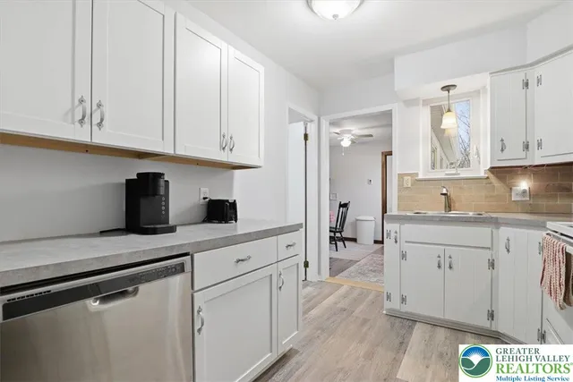 a kitchen with granite countertop white cabinets and white appliances