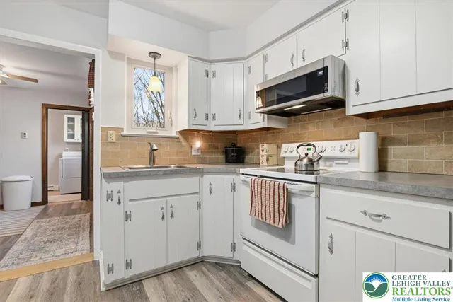 a kitchen with granite countertop white cabinets stainless steel appliances and sink