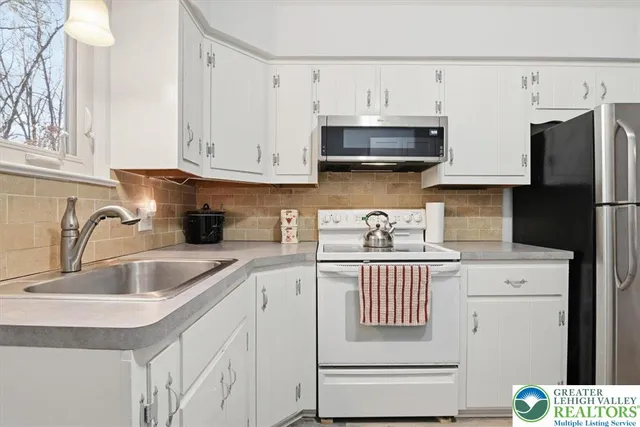 a kitchen with stainless steel appliances granite countertop a sink and a refrigerator