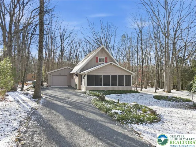 a front view of a house with a yard covered with snow