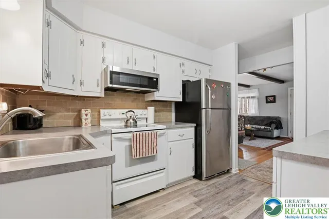 a kitchen with white cabinets and stainless steel appliances