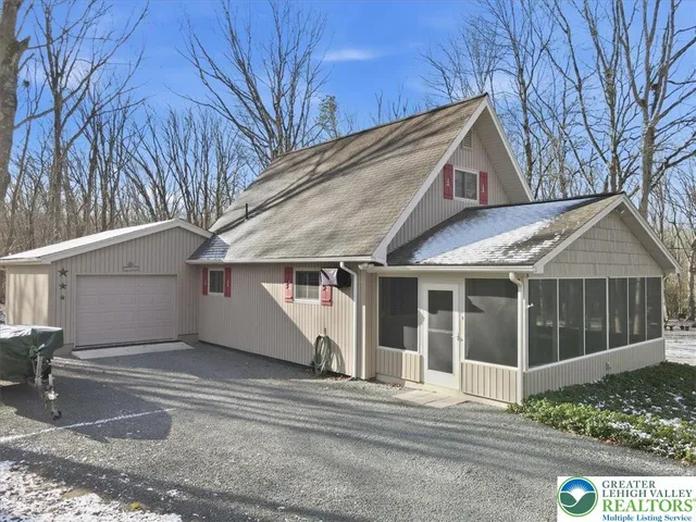 a view of a white house with a large tree