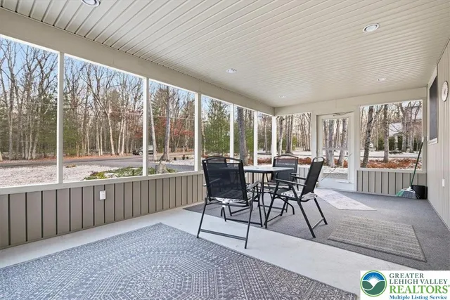a dining room with furniture and a large window