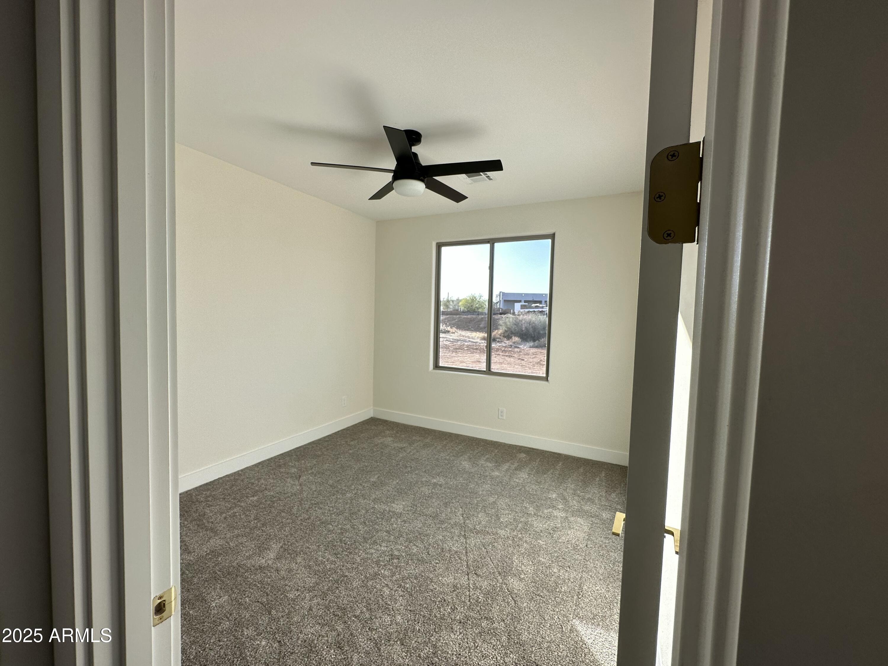 5749 North Nigal Road Casa Grande, AZ 85194 - Photo 14 of 15 en empty room with windows and ceiling fan