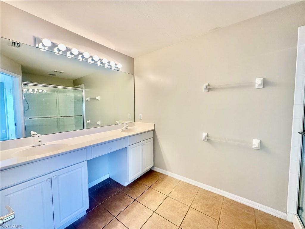 996 Hampton Circle, Unit 71 Naples, FL 34105 - Photo 14 of 30 a bathroom with a double vanity sink and a mirror