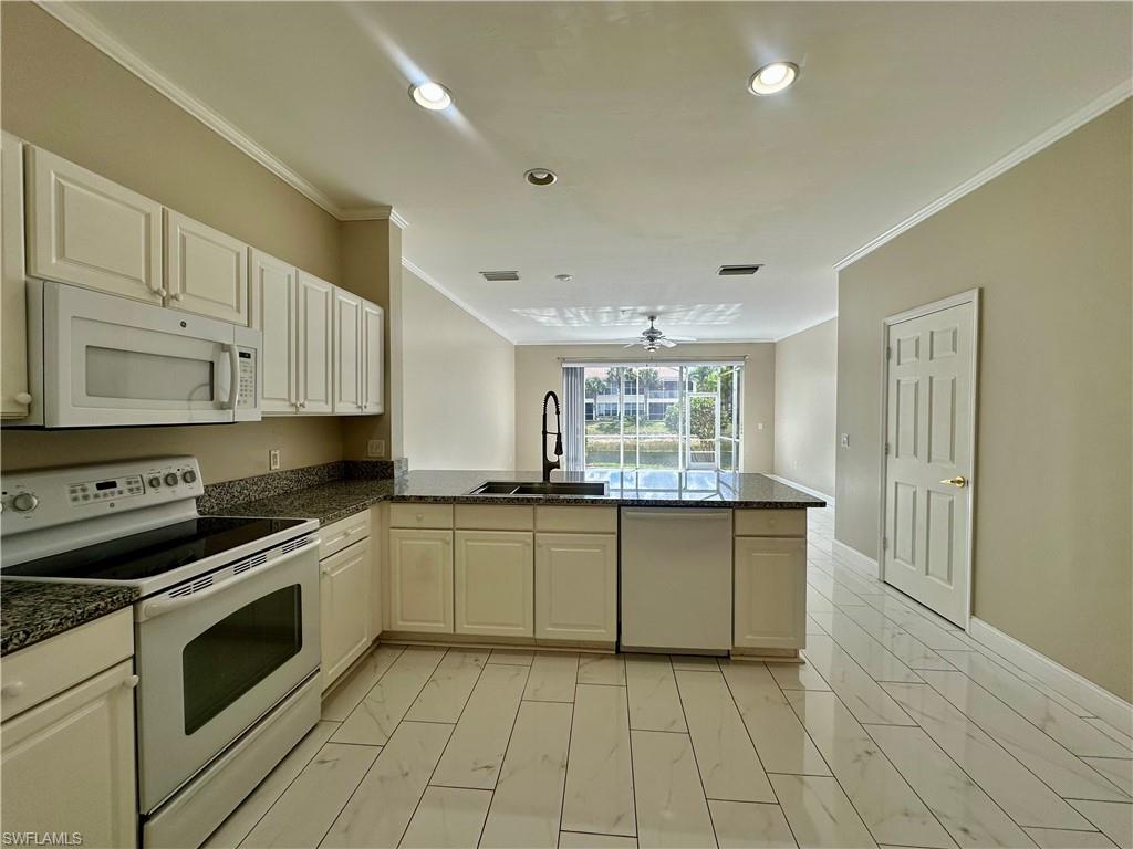 996 Hampton Circle, Unit 71 Naples, FL 34105 - Photo 5 of 30 a kitchen with stainless steel appliances a stove sink and cabinets