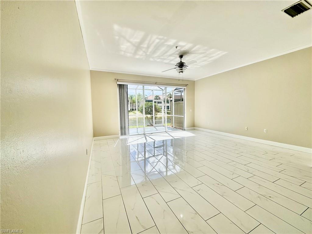 996 Hampton Circle, Unit 71 Naples, FL 34105 - Photo 7 of 30 wooden floor in an empty room with a window