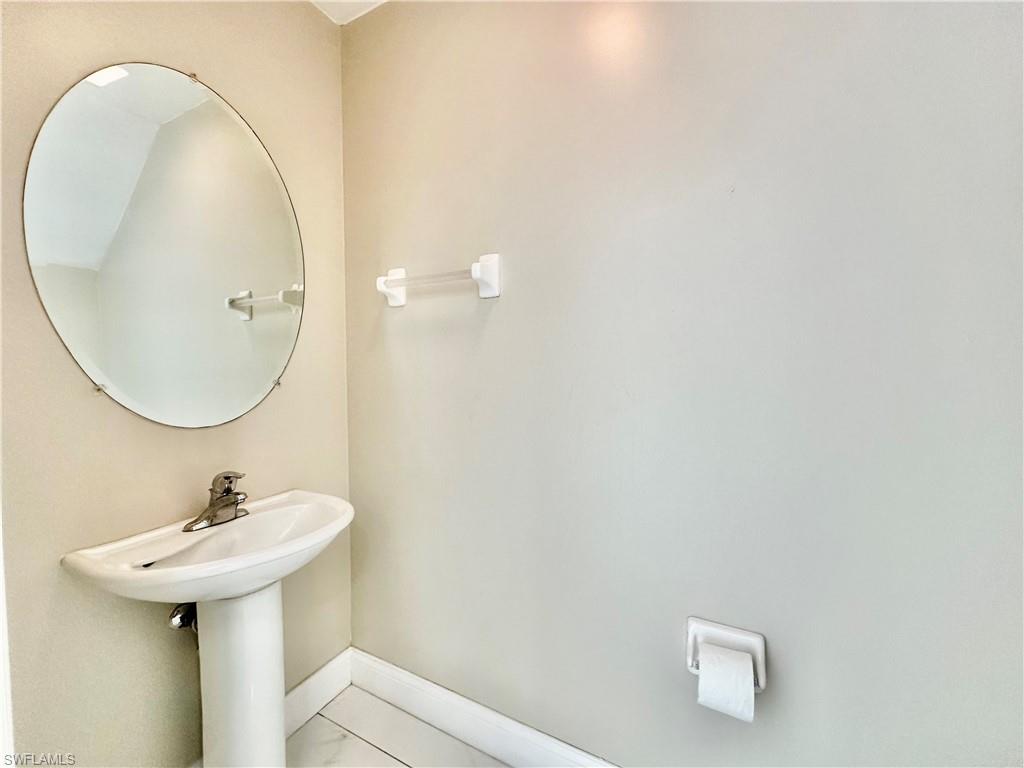 996 Hampton Circle, Unit 71 Naples, FL 34105 - Photo 8 of 30 a bathroom with a sink a mirror and a toilet