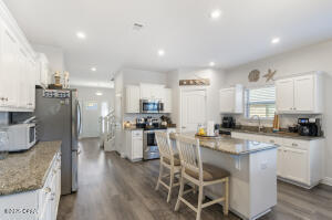 113 Ridgeway Circle Crestview, FL 32536 - Photo 12 of 55 a kitchen with a sink a stove a refrigerator and chairs