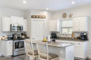a kitchen with appliances a sink a counter top space and cabinets
