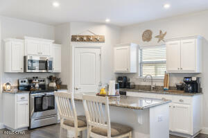 113 Ridgeway Circle Crestview, FL 32536 - Photo 9 of 55 a kitchen with stainless steel appliances a sink a stove a refrigerator cabinets and a window