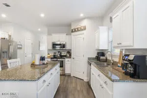a kitchen with a sink a stove a refrigerator and chairs