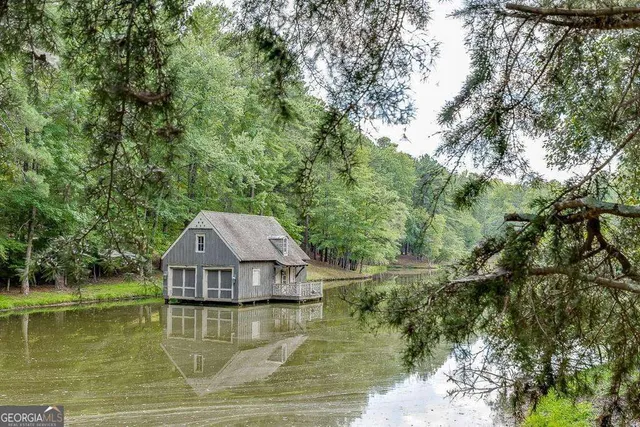 a view of a lake with a yard and large trees