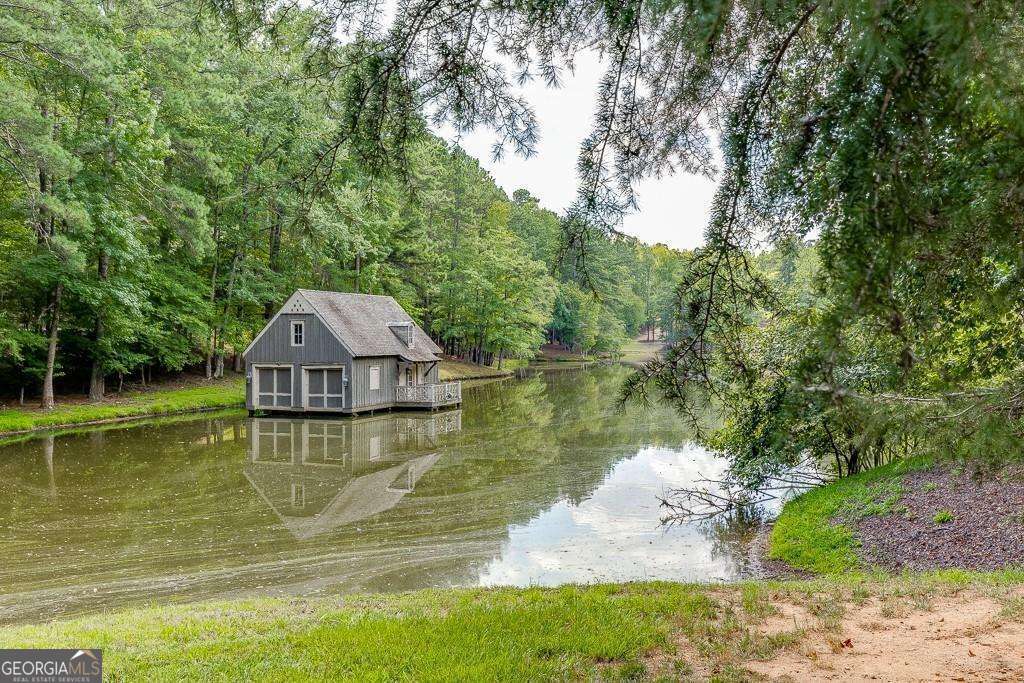5755 Kennedy Road Buford, GA 30024 - Photo 13 of 23 a view of a lake with a yard and large trees