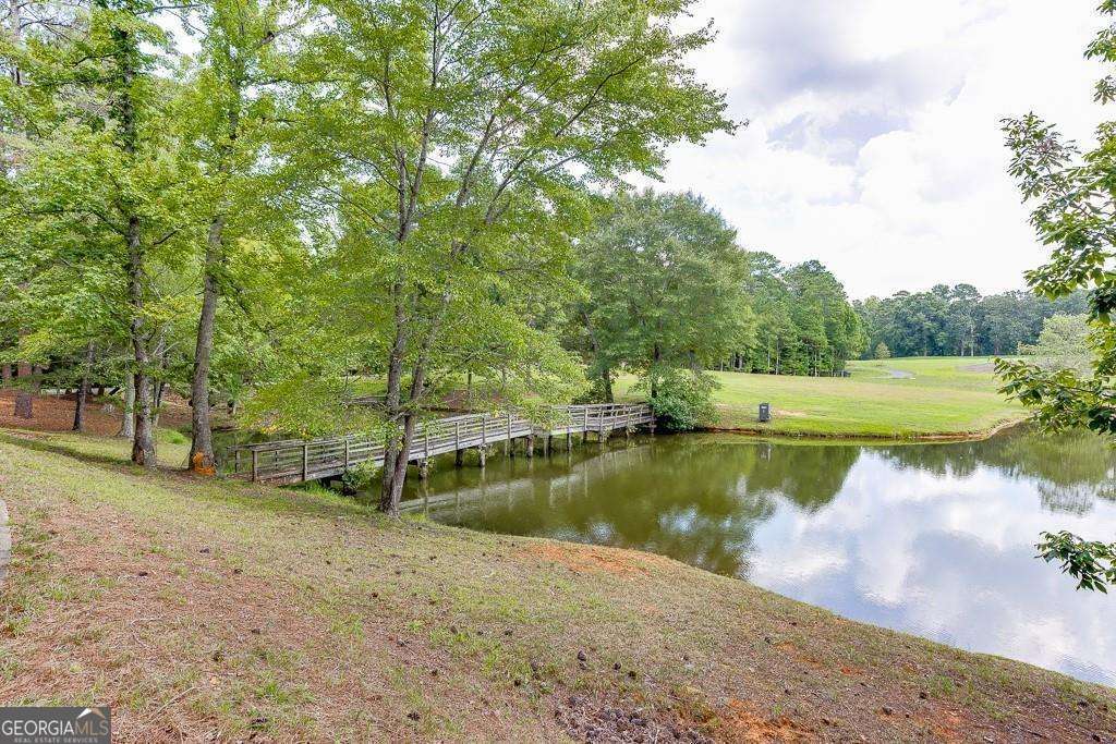 5755 Kennedy Road Buford, GA 30024 - Photo 7 of 23 a view of a lake with a yard and large trees