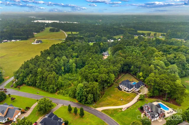 an aerial view of a house with a swimming pool outdoor seating yard and mountain view