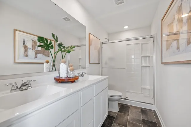 a bathroom with a granite countertop sink a toilet and shower