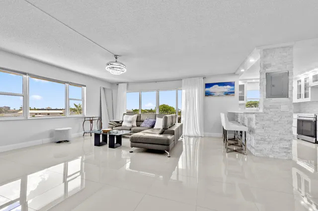 a living room with furniture and a kitchen view