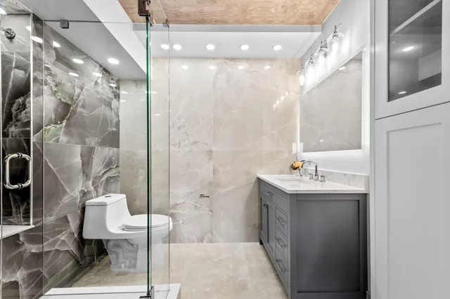 a bathroom with a sink a toilet and shower