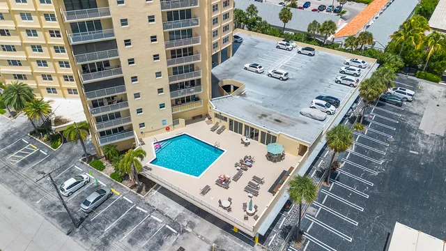 a view of a swimming pool and deck with lawn chairs