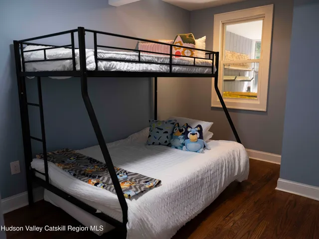 a bed sitting in a bedroom next to a window