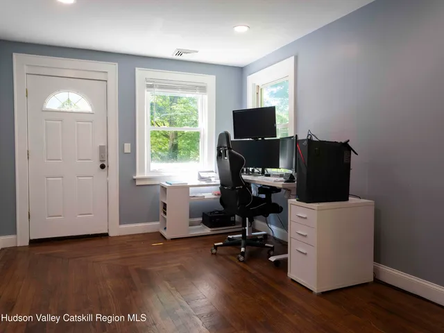 a view of a workspace with furniture and a window