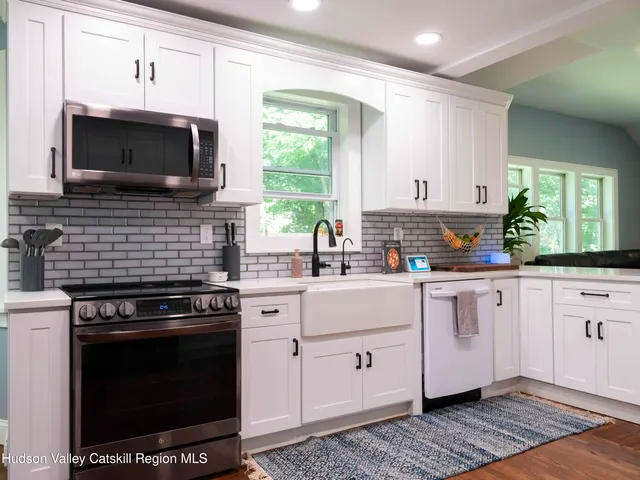 a kitchen with stainless steel appliances a stove a microwave a sink and cabinets