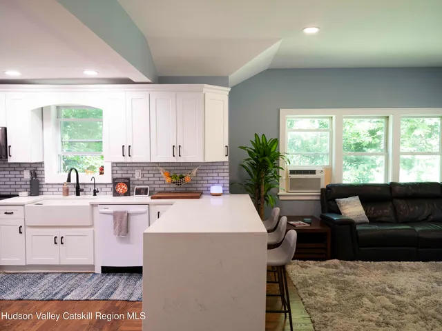 a kitchen with kitchen island granite countertop a sink and white cabinets