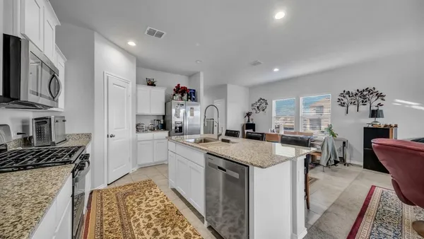 a kitchen with granite countertop a sink stove and cabinets