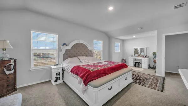 a spacious bedroom with a bed and a window