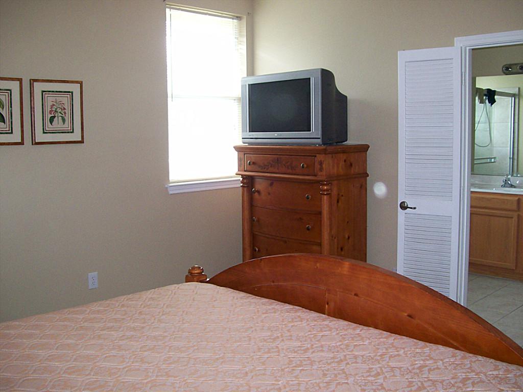 811 Bradford Avenue, Unit 5B Kemah, TX 77565 - Photo 13 of 22 a bedroom with a bed and a flat screen tv