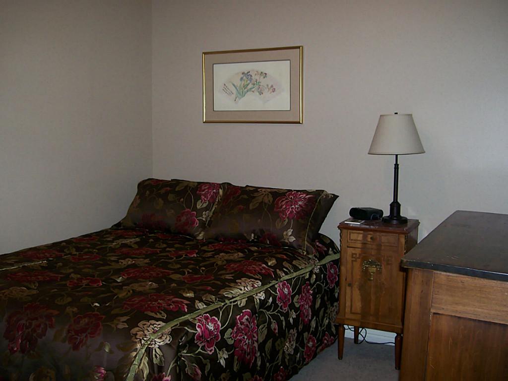 811 Bradford Avenue, Unit 5B Kemah, TX 77565 - Photo 16 of 22 a bed sitting in a bedroom next to a window and a lamp