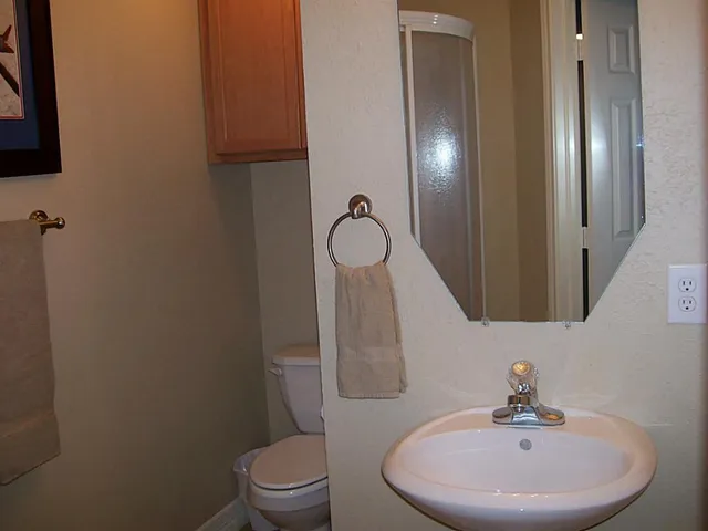 a bathroom with a toilet sink and mirror