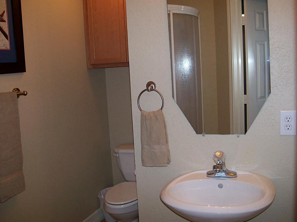 811 Bradford Avenue, Unit 5B Kemah, TX 77565 - Photo 17 of 22 a bathroom with a toilet sink and mirror