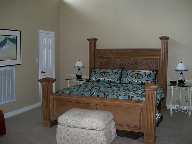 a bed sitting in a bedroom next to a window