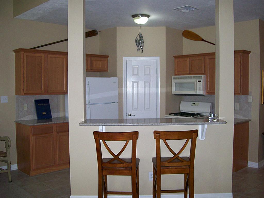 811 Bradford Avenue, Unit 5B Kemah, TX 77565 - Photo 7 of 22 a kitchen with stainless steel appliances granite countertop a stove a sink and a refrigerator