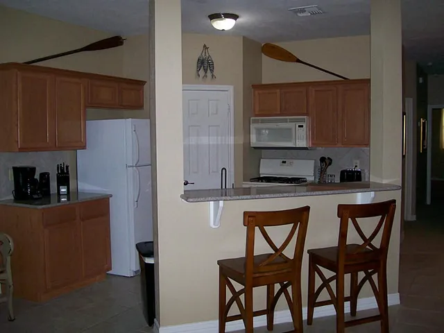 a kitchen with stainless steel appliances granite countertop a refrigerator a sink and wooden cabinets