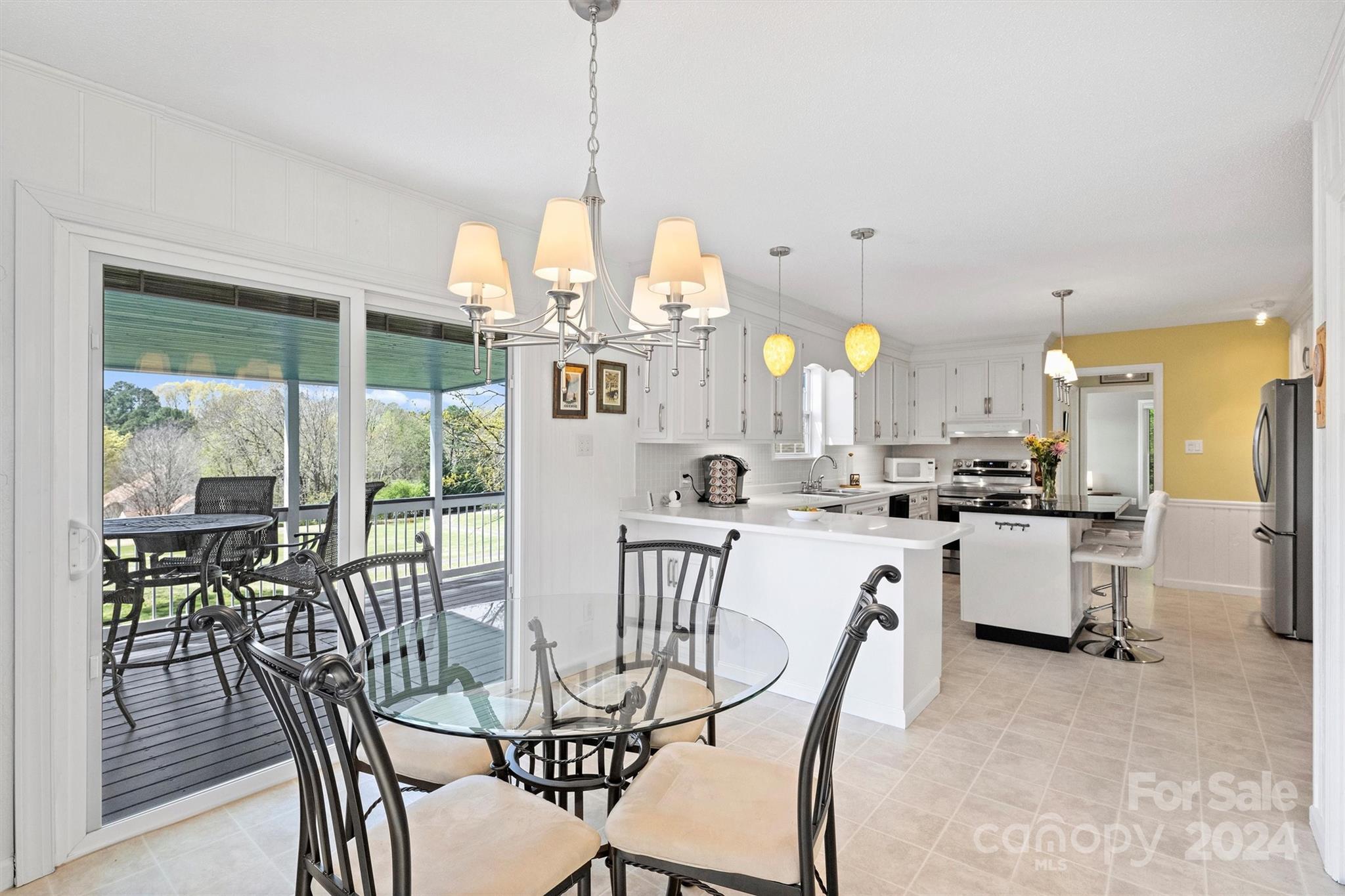 1190 Molokai Drive Tega Cay, SC 29708 - Photo 13 of 46 a view of a dining room and livingroom with furniture large windows a chandelier