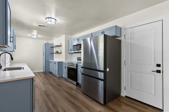 a kitchen with stainless steel appliances a refrigerator and a sink