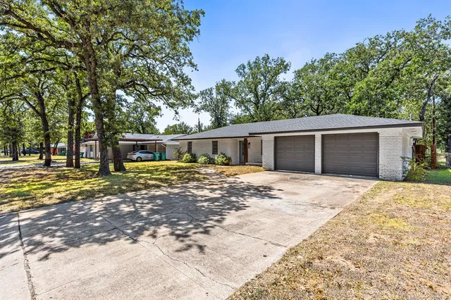 a front view of a house with a yard and trees