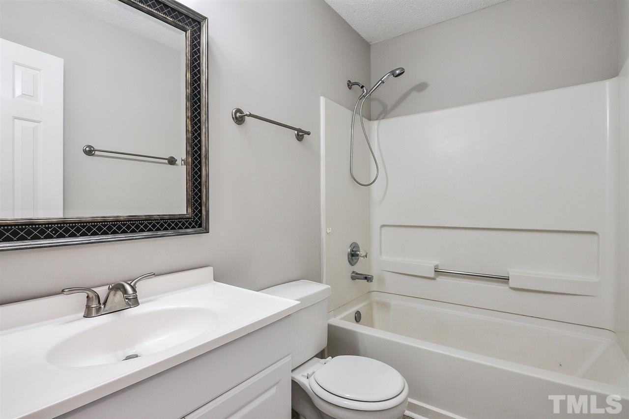 5208 Relay Way Raleigh, NC 27603 - Photo 19 of 25 a bathroom with a granite countertop sink toilet a mirror and shower