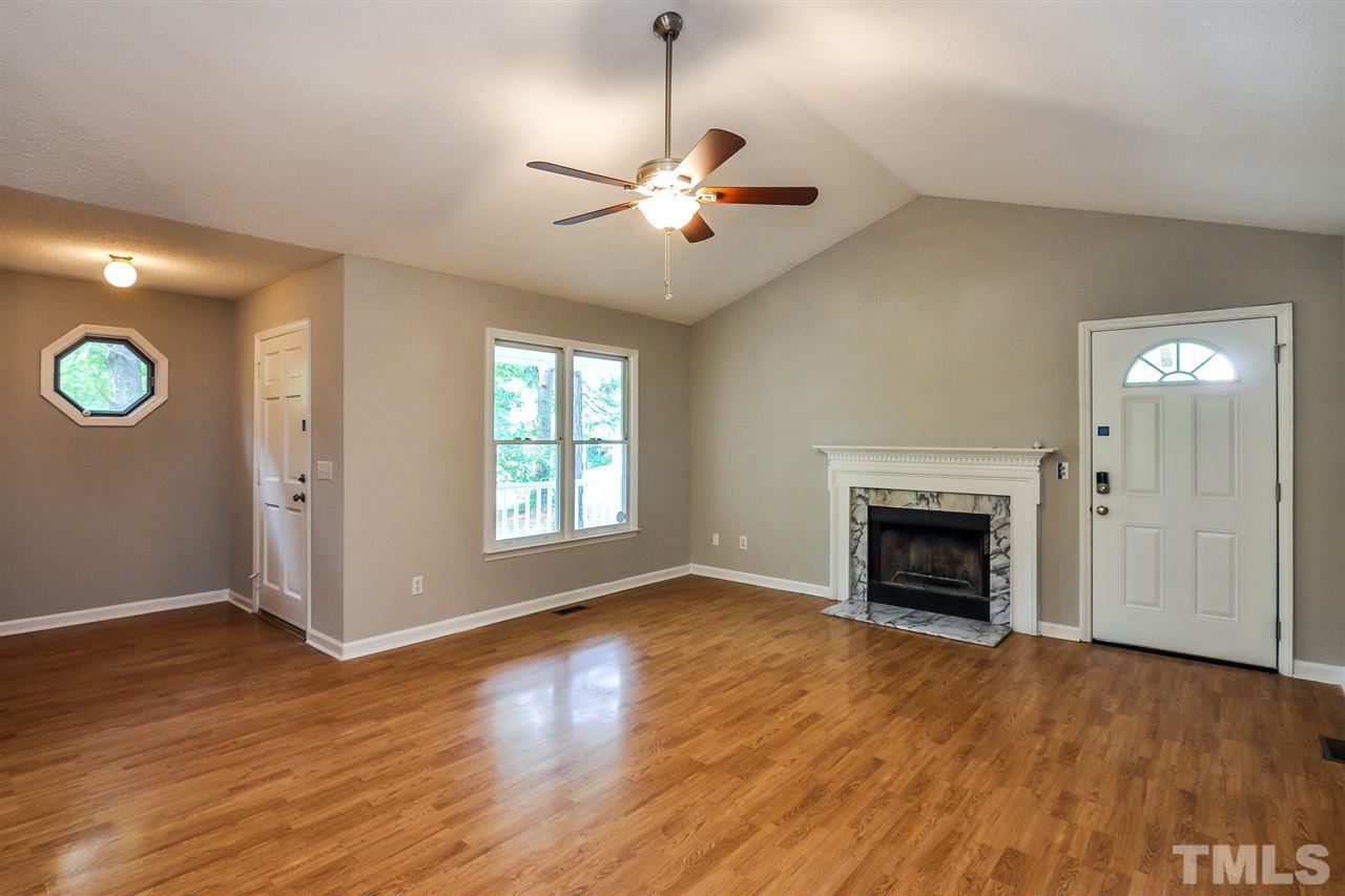 5208 Relay Way Raleigh, NC 27603 - Photo 3 of 25 an empty room with windows fireplace and a wooden floor