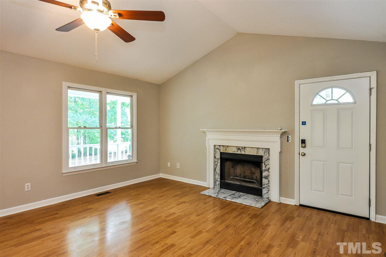 5208 Relay Way Raleigh, NC 27603 - Photo 8 of 25 a view of an empty room with wooden floor fireplace and a window