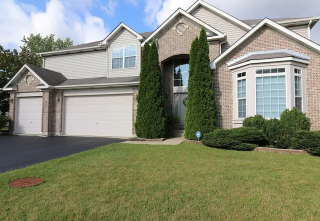 a front view of a house with a yard and garage