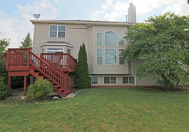 a view of a house with a yard and deck