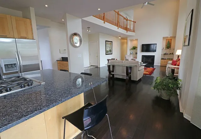 a kitchen with stainless steel appliances granite countertop a sink dishwasher and cabinets with wooden floor