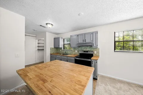 a kitchen with granite countertop a refrigerator stove top oven and sink