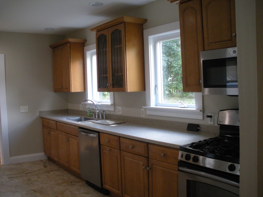 113 Rockland Street, Unit 1 Canton, MA 02021 - Photo 5 of 9 a kitchen with a sink a window and cabinets