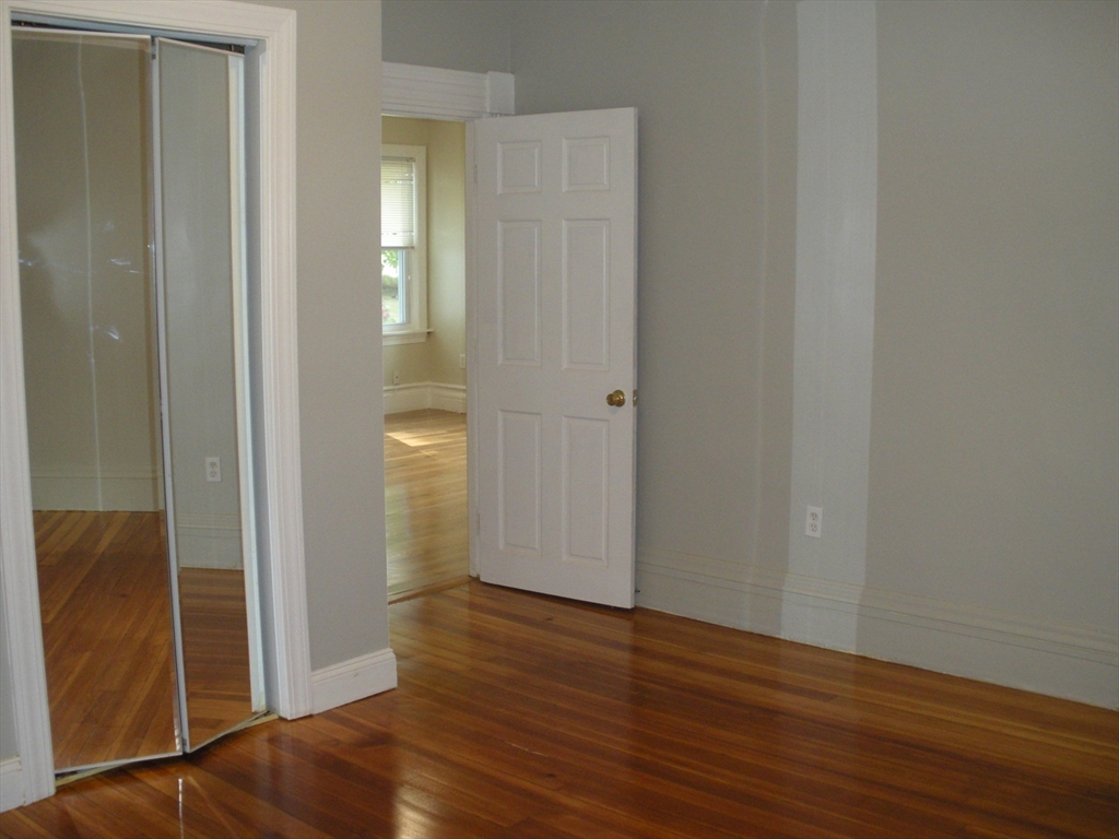 113 Rockland Street, Unit 1 Canton, MA 02021 - Photo 7 of 9 a view of an empty room with wooden floor and a bathroom